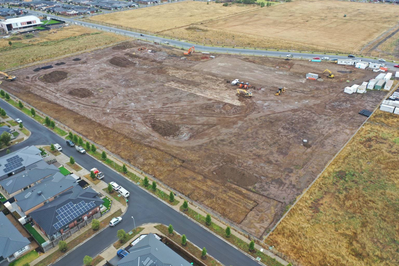 Merrifield South Primary School (interim name) - construction photo of site progress in January 2023 - aerial shot of site showing portables, flattened earth and surrounding roads
