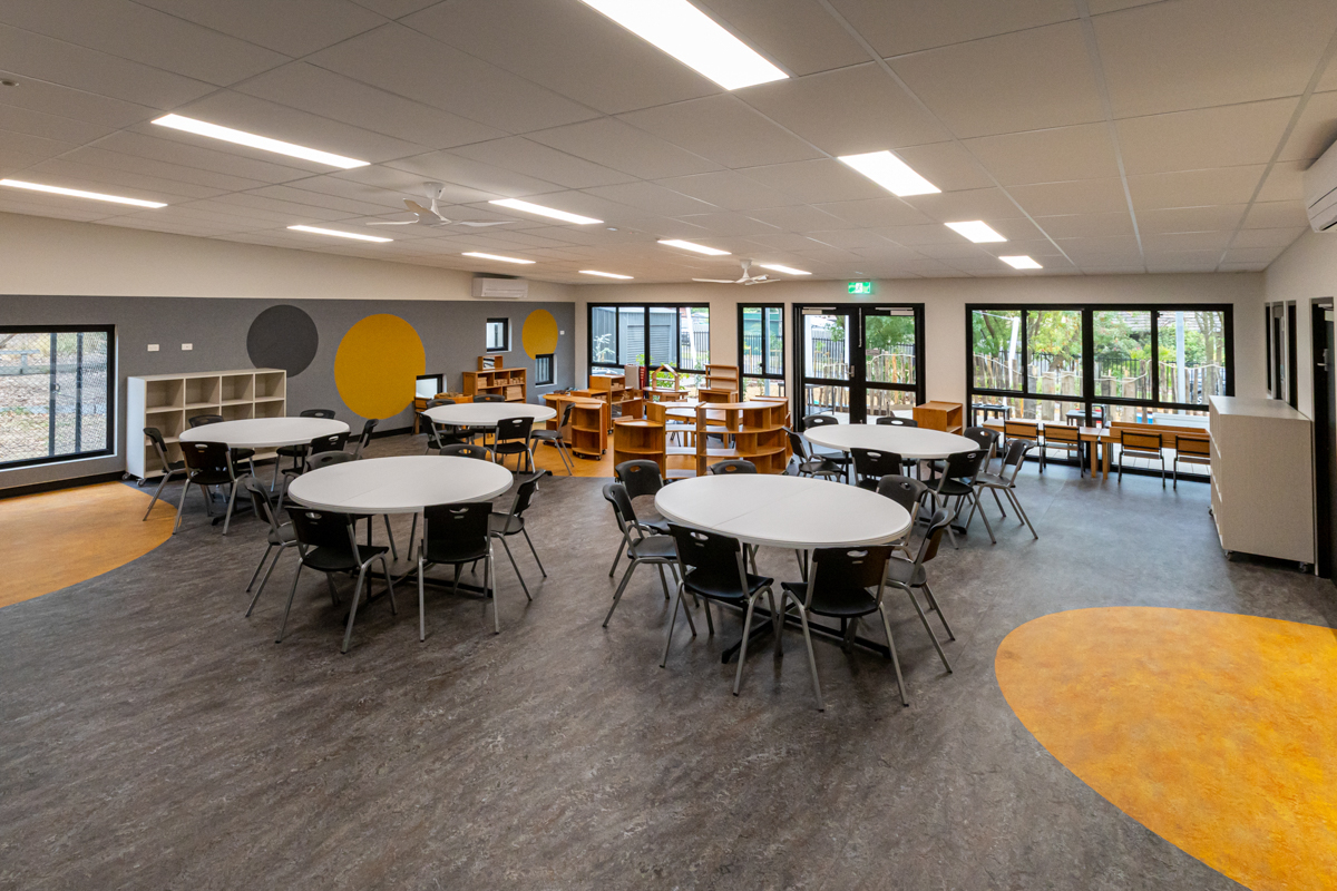 Reservoir East Family Centre - photo of circular tables and chairs in a large yellow and grey dot-patterned space