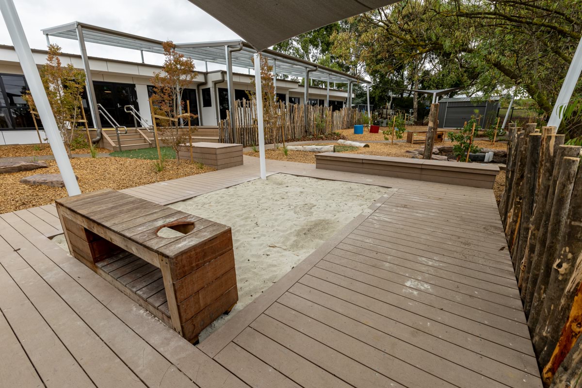 Reservoir East Family Centre - photo of a shaded sandpit in a landscaped outdoor play space  