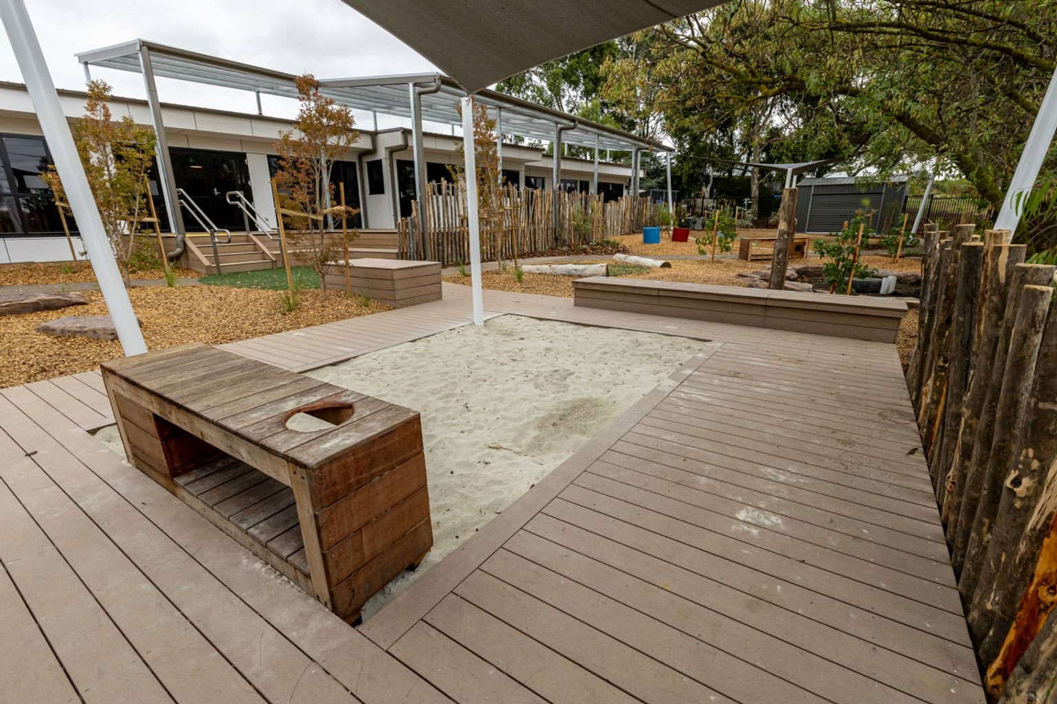 Reservoir East Family Centre - photo of a shaded sandpit in a landscaped outdoor play space  