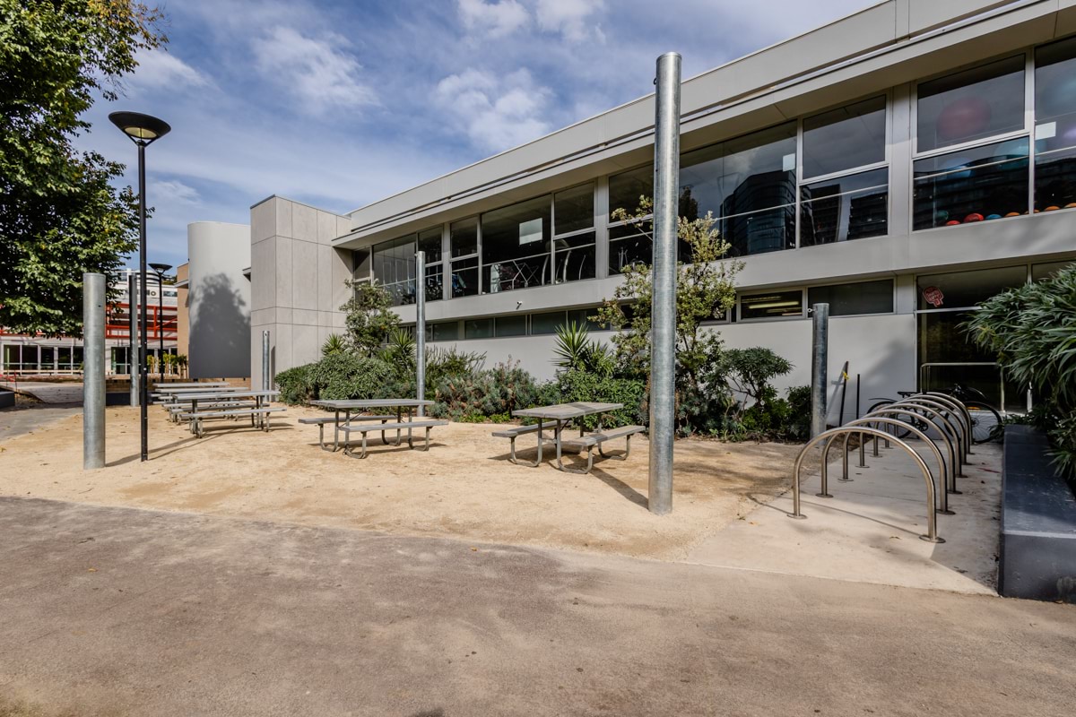 The outside of a school building with picnic benches.  
