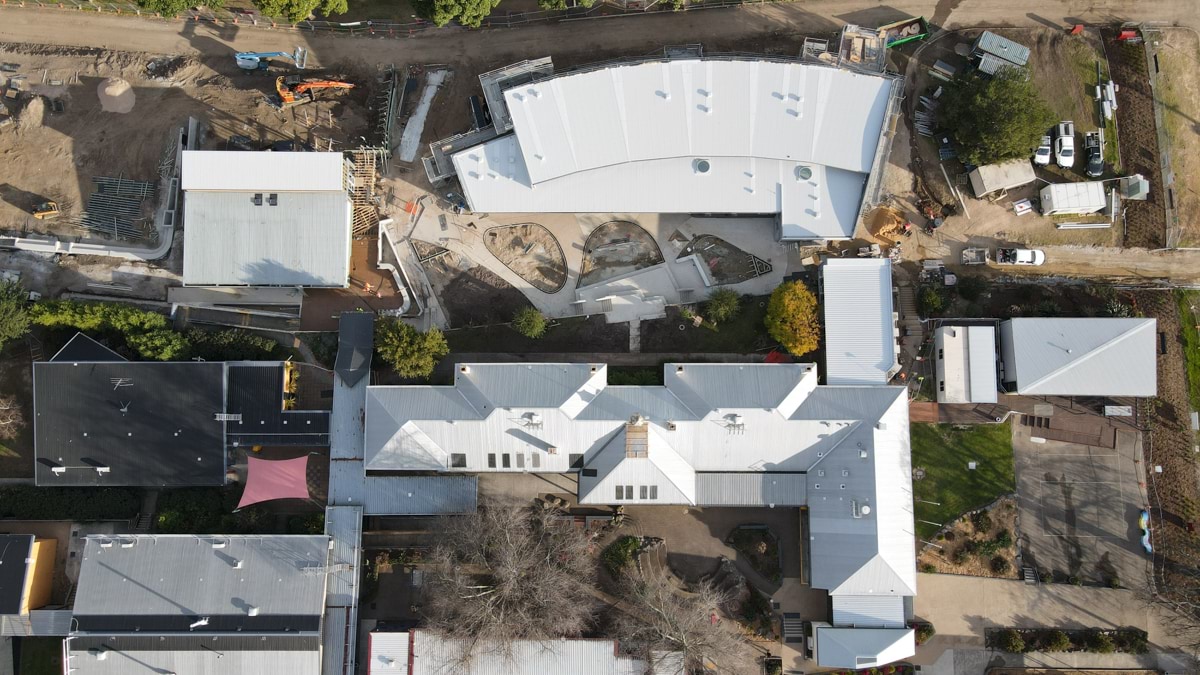 This is an aerial image of the Orbost Community College construction site. It shows the exterior of a new school building amongst existing school infrastructure and the surrounding site.