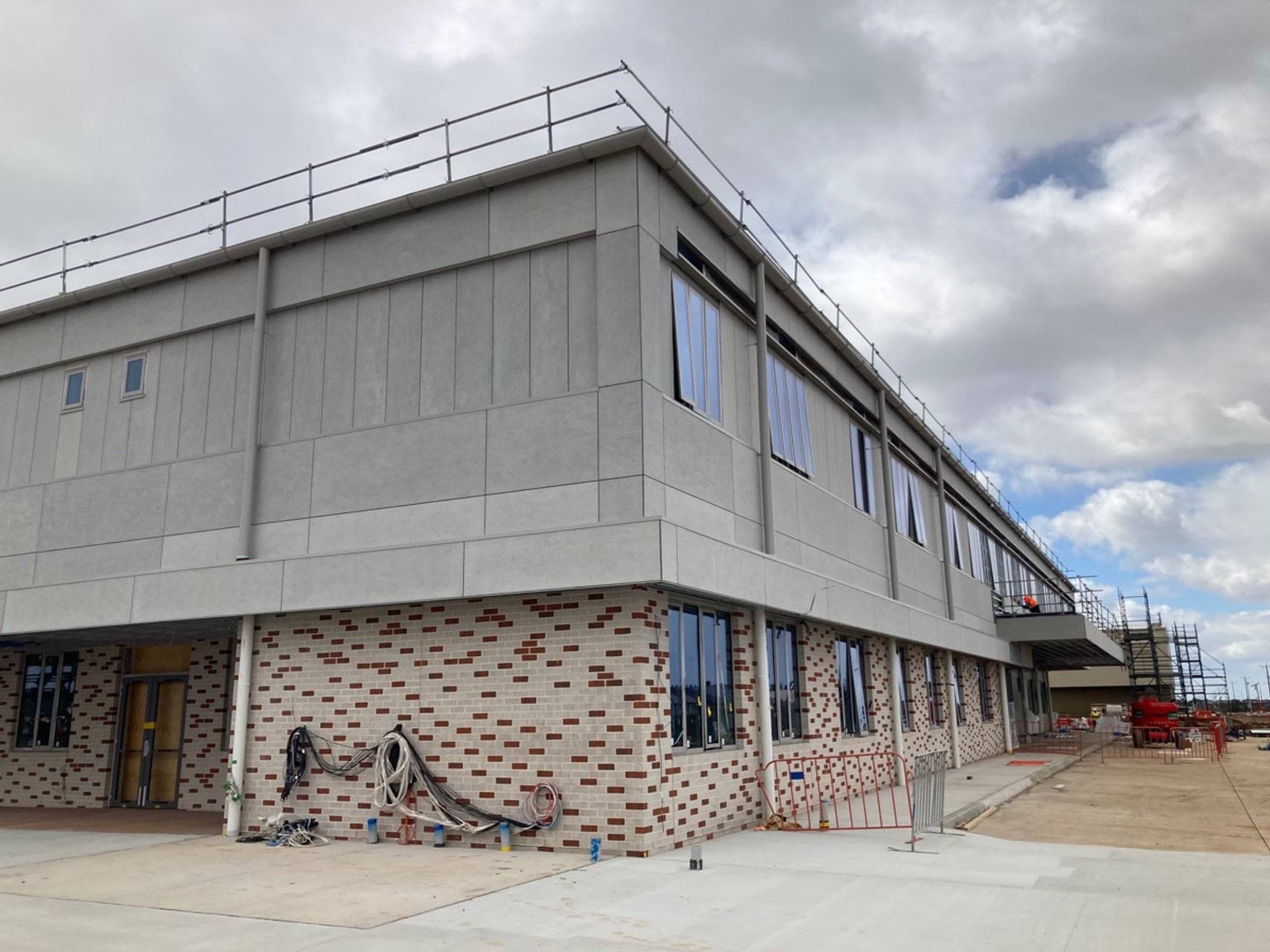 Exterior tiling of building red and white and above this a concrete render