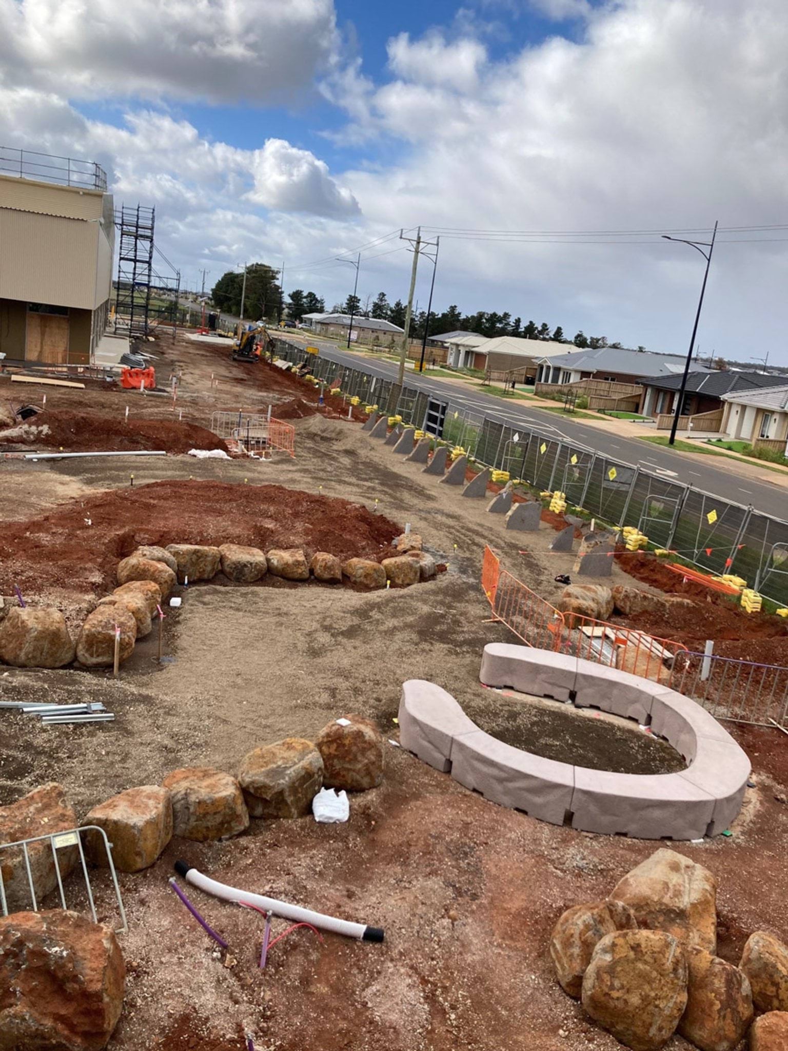Landscaping underway with circular seating and garden beds enclosed with rocks