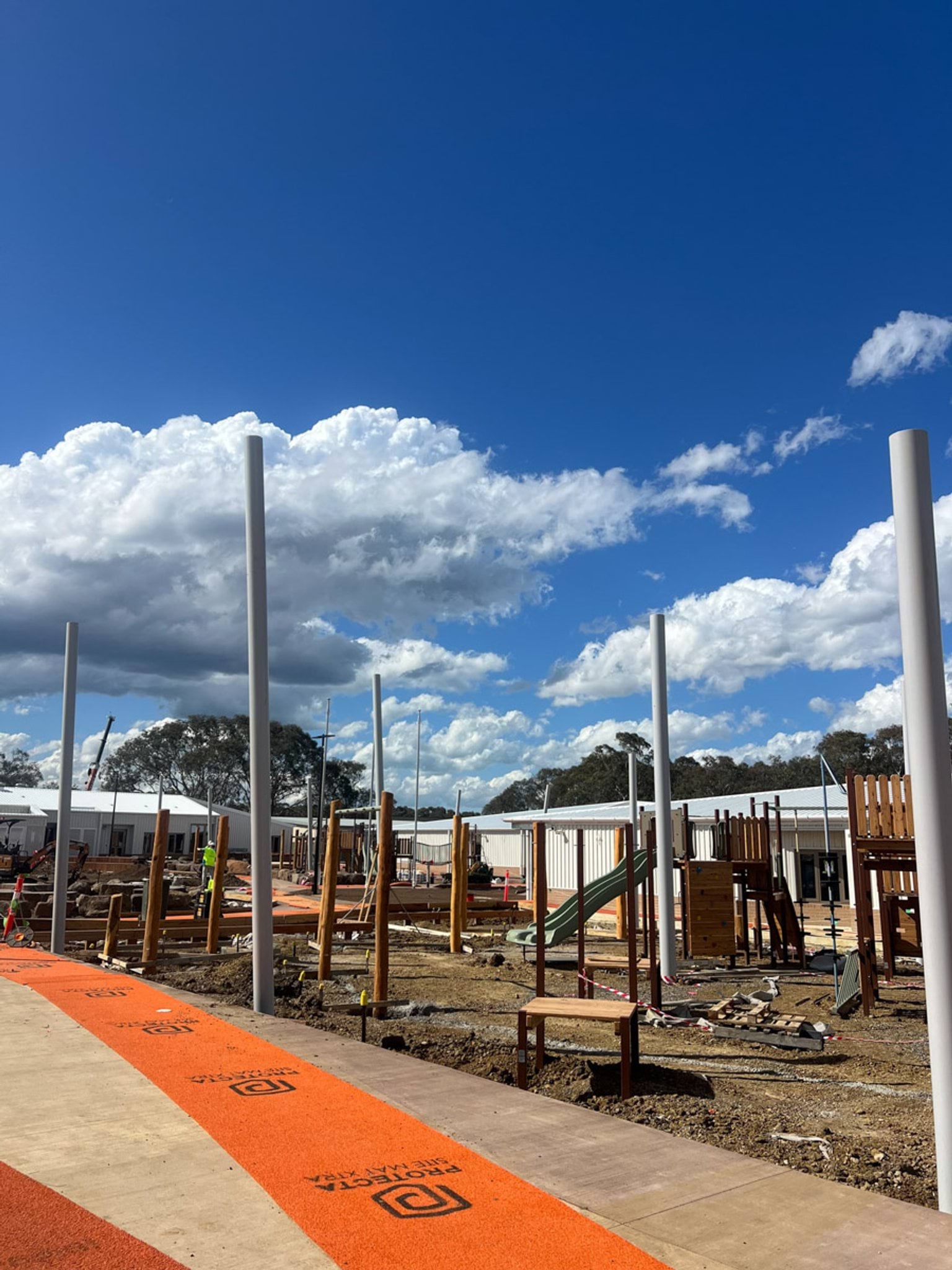 Red path runs alongside playground. Posts are up without sail cloth as of yet