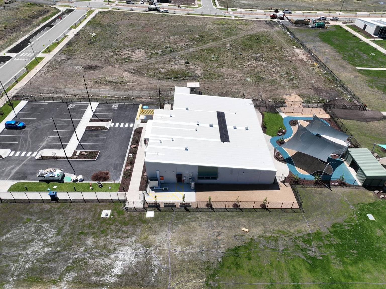 Aerial photo of the current Muyan Primary School Kindergarten (interim name) construction progress. It looks nearly finished, with a car park on the left, building in the middle and a covered outdoor area to the right. 