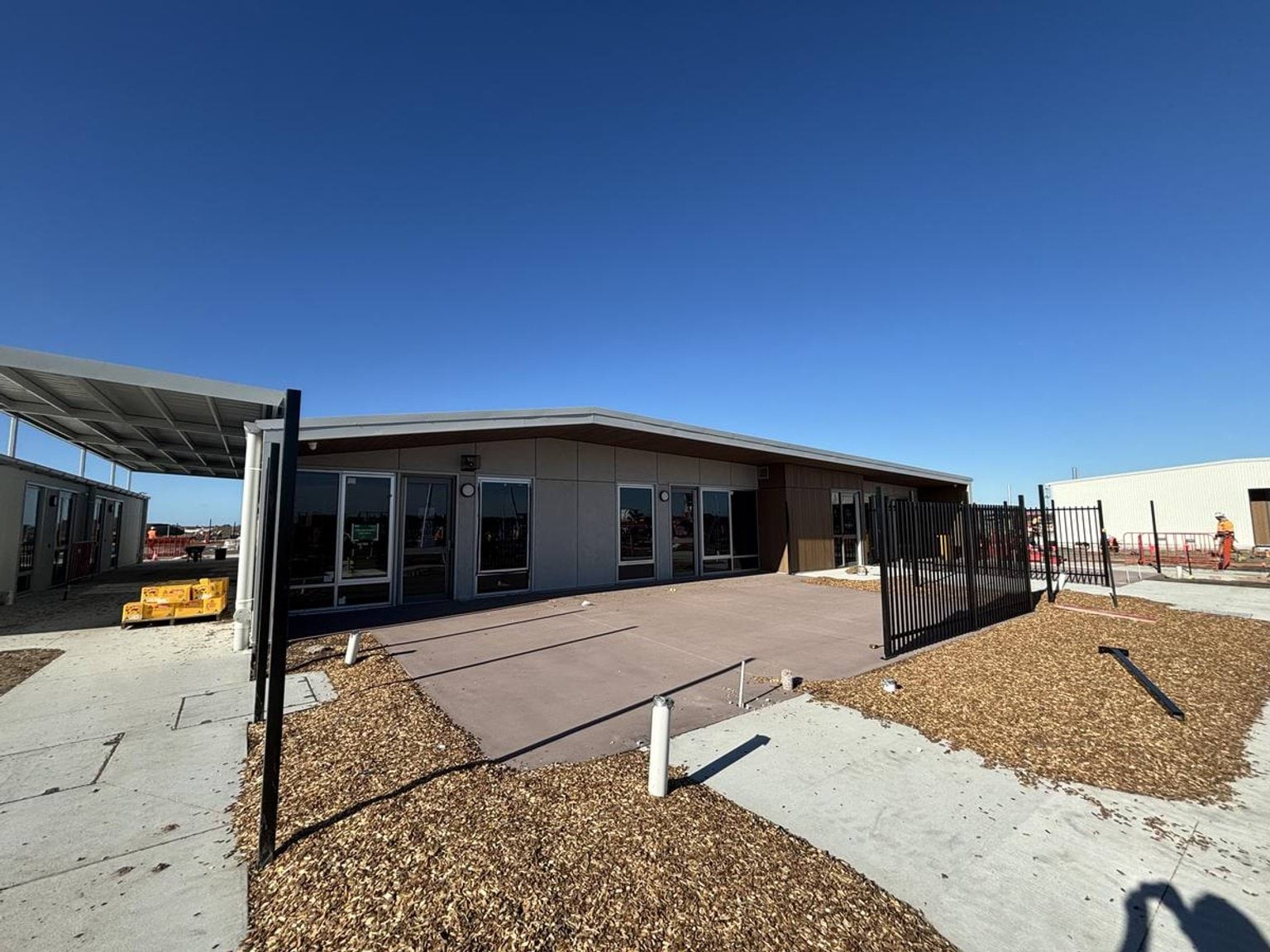 A photo of the outside of a new building at Ngurraga School. It looks almost finished, and there is a concrete path leading to it.