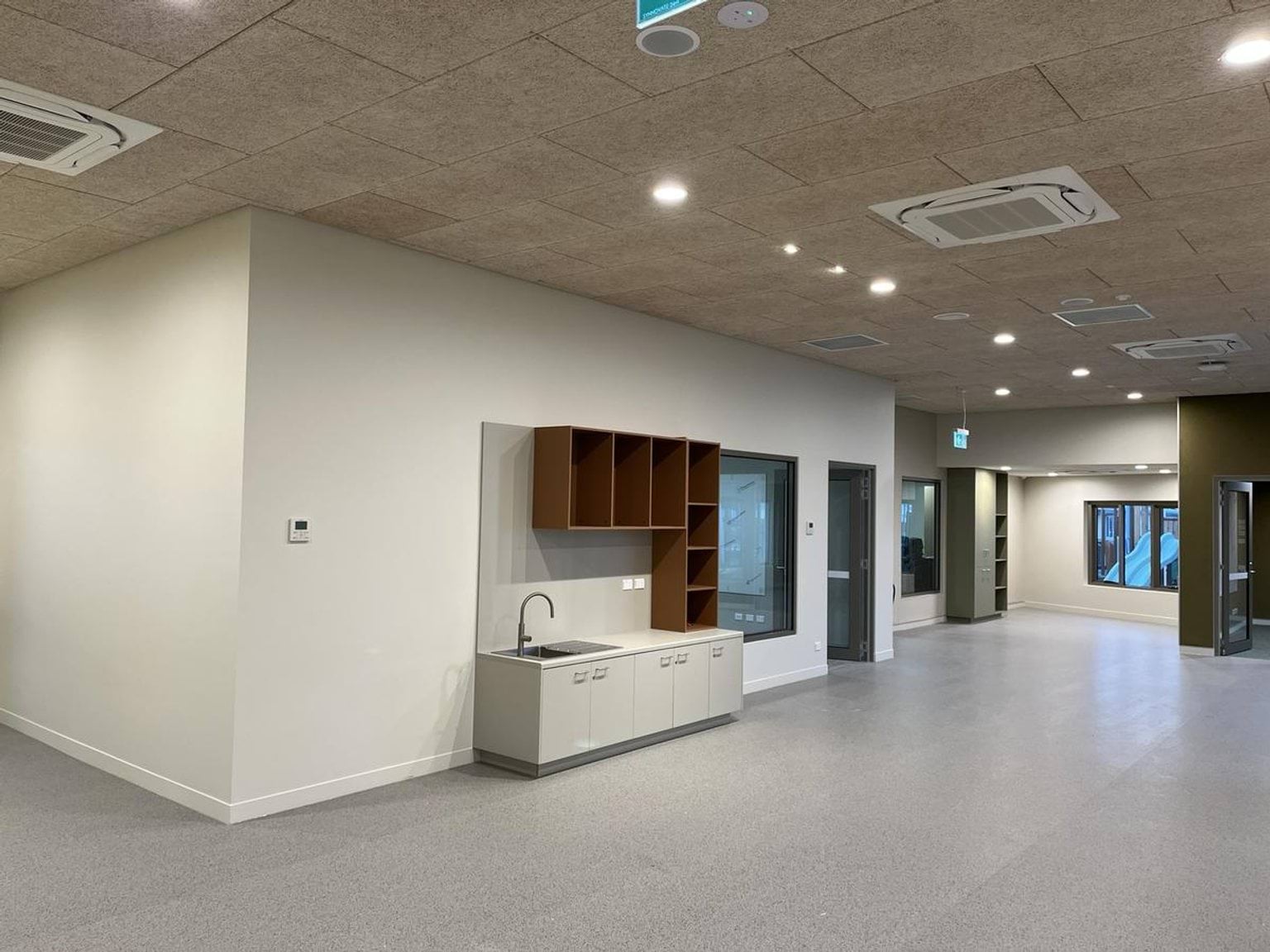 Indoor school room with sink, shelves and cupboards