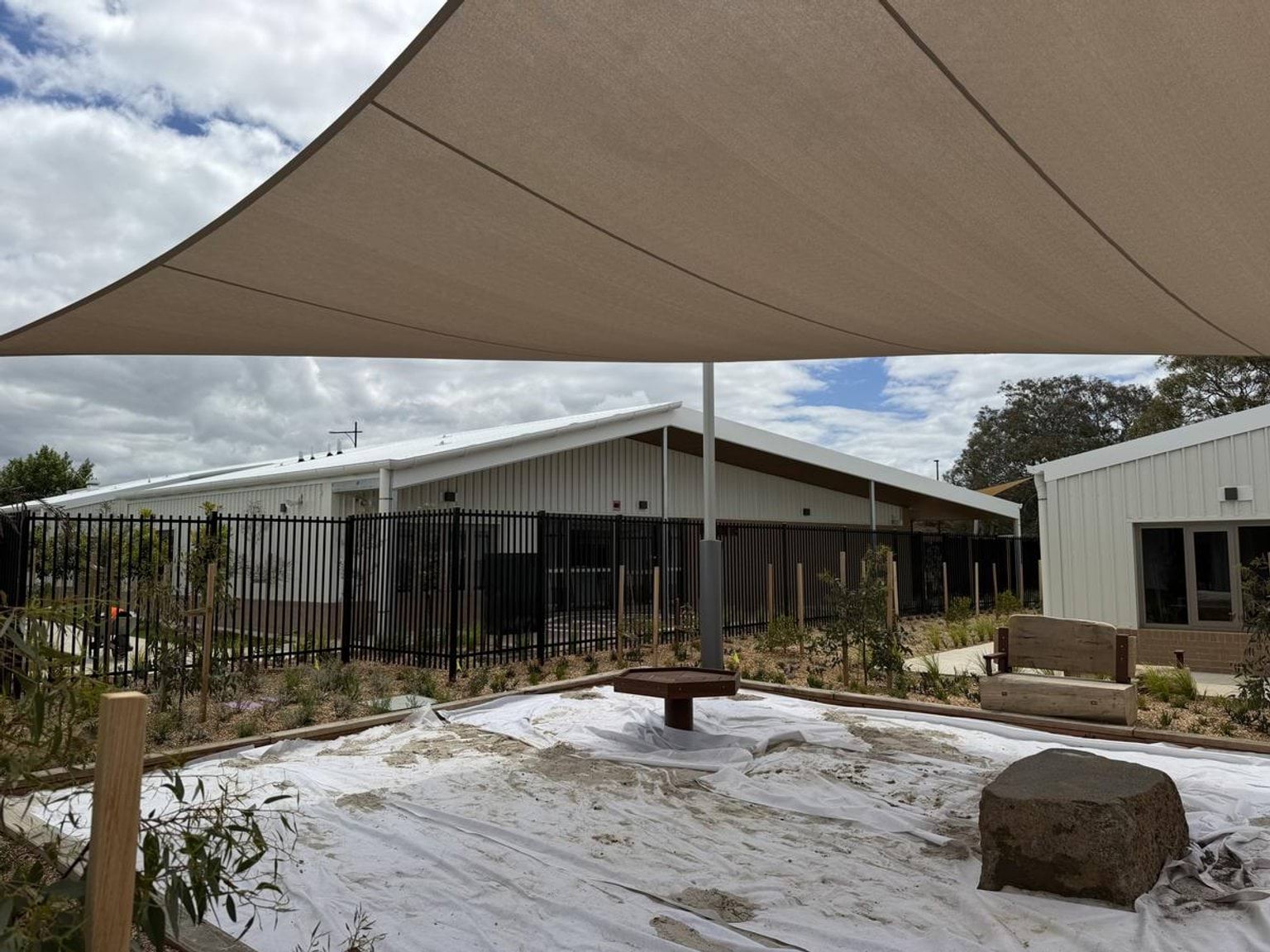 Outside play area of Biyala Primary School Kindergarten (interim name), under a big shade sail. A building is visible in the background.
