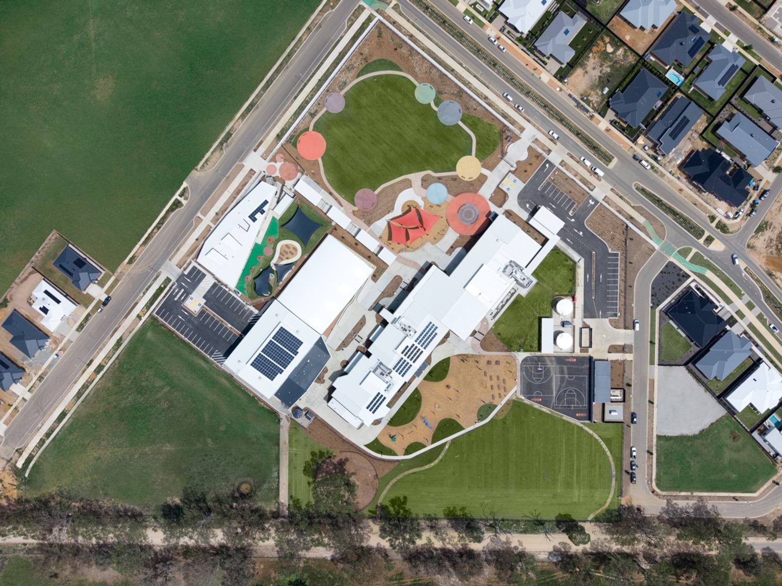 Top‑down aerial view of entire school site showing buildings, play zones, sports areas and car parks.