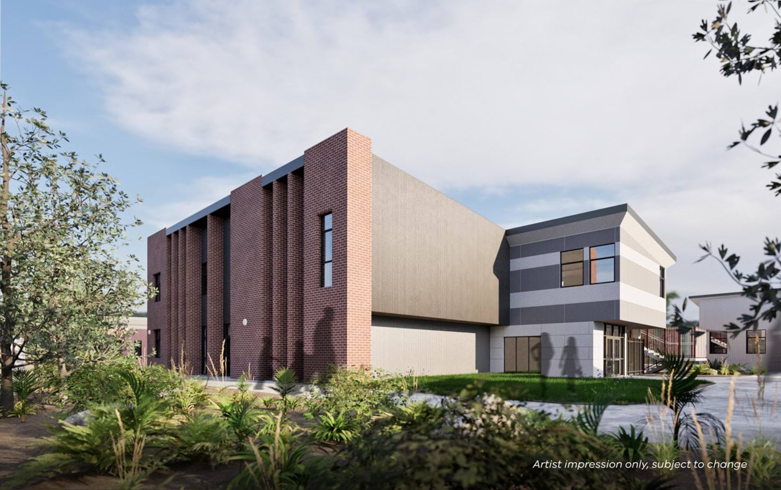 Rear view of the modern two-storey school featuring brick detailing, large windows, and surrounding greenery.