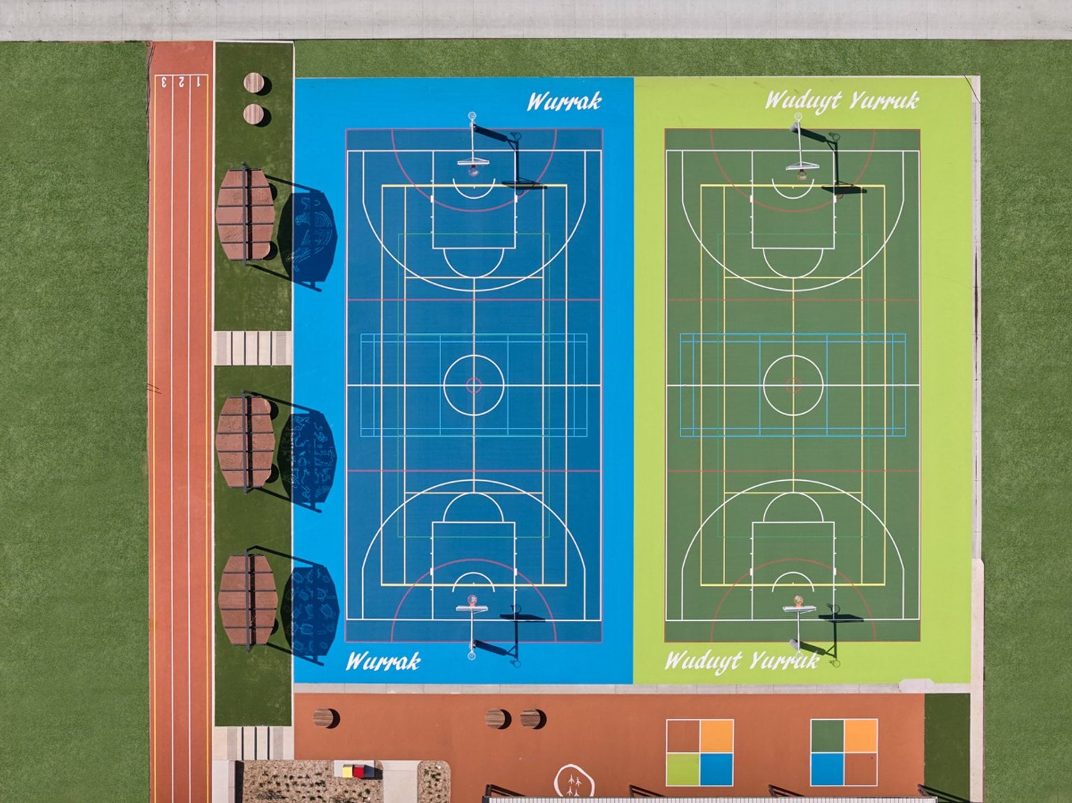 A top‑down view of two outdoor sports courts marked “Wurrak” and “Wudyit Yurruk,” with nearby shade structures and a running track.