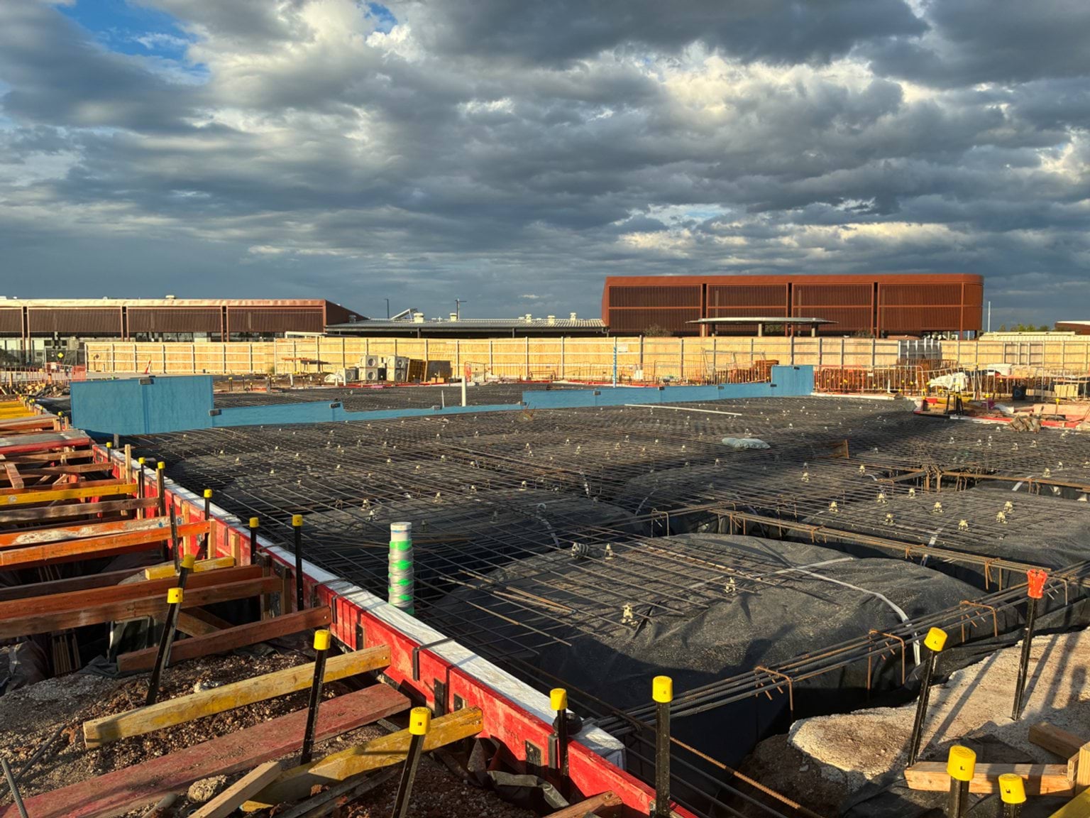 Reinforced slab preparation at a school building site, with steel mesh laid across formwork before concrete placement.