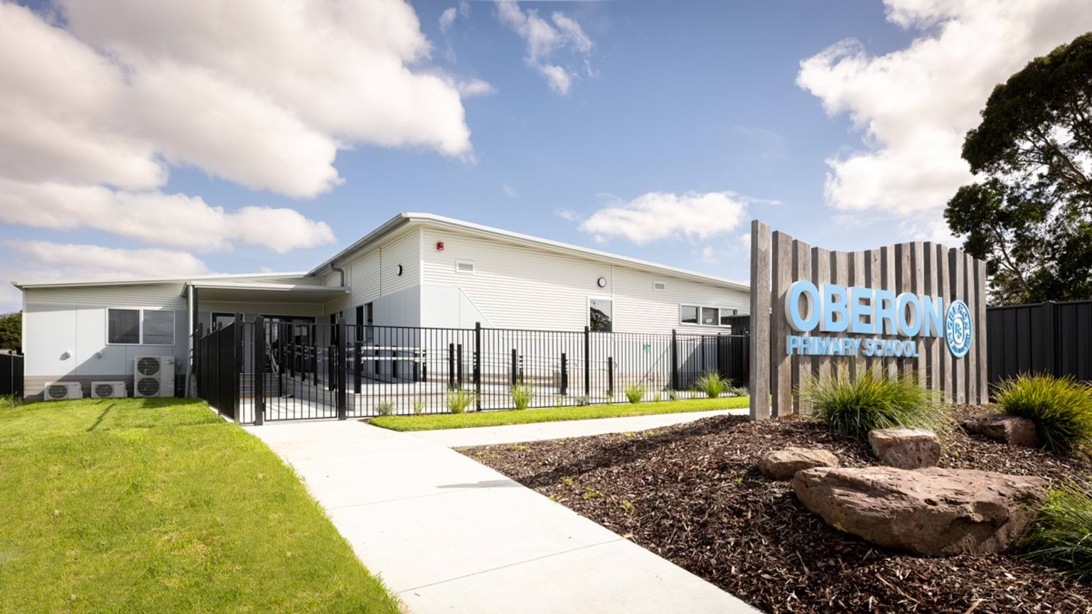 Exterior view of Oberon Primary School with entrance fencing, landscaped garden and school signage.