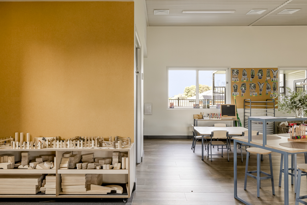 Classroom area with wooden construction blocks, tables and creative learning materials.