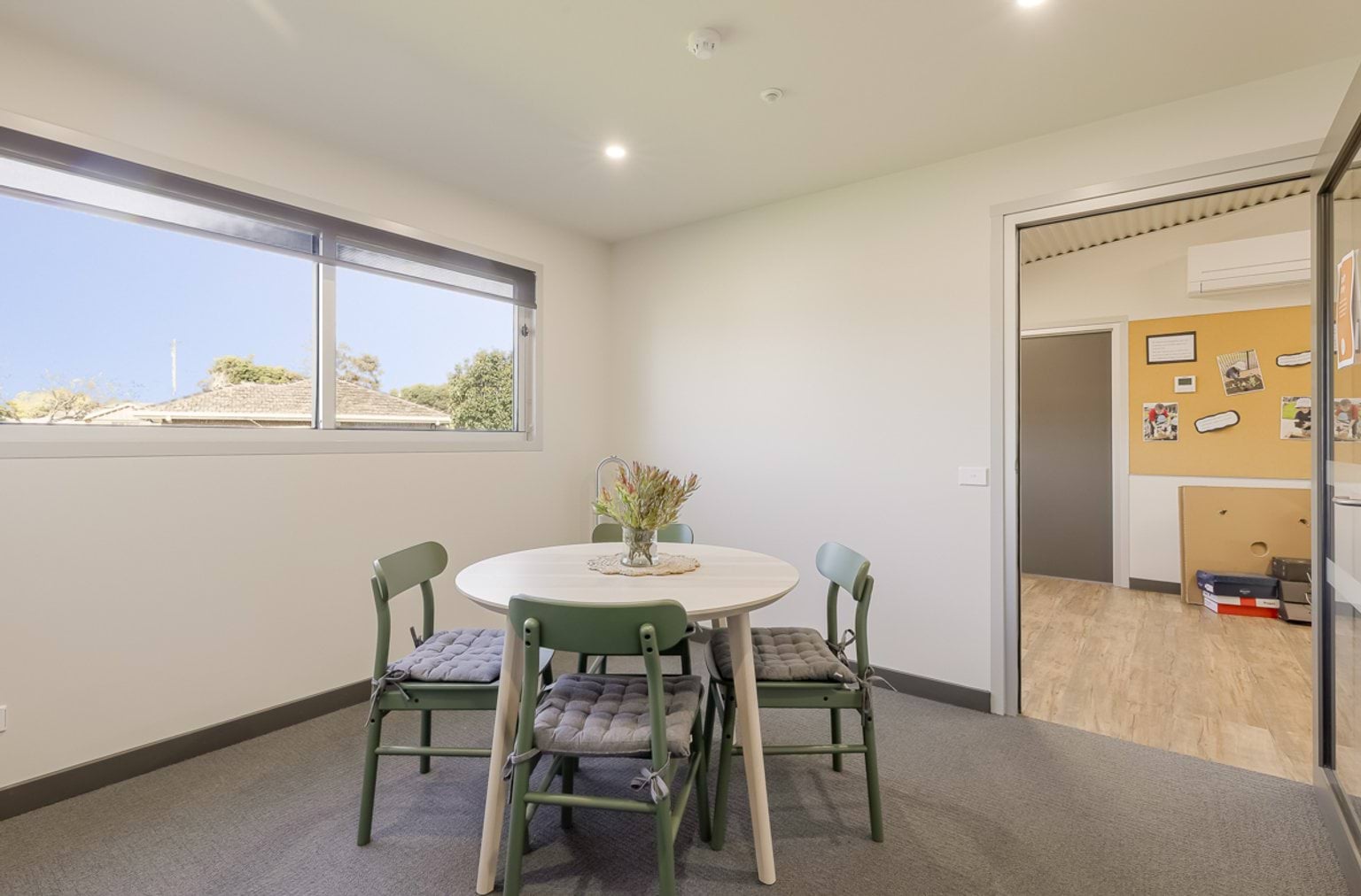 Small meeting or quiet room with round table, four chairs and natural light from a window.