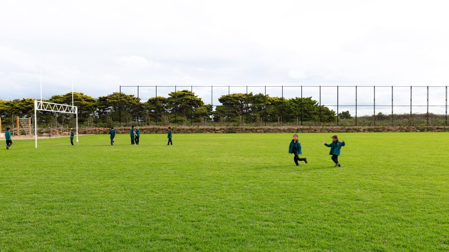 Students playing on grass rugby field