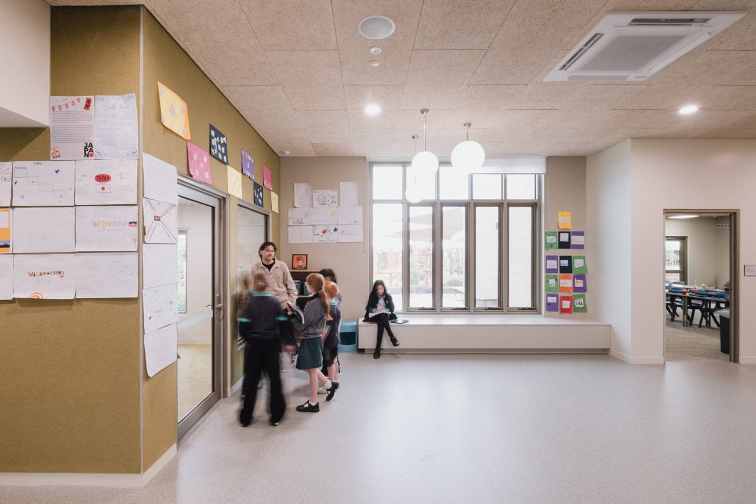 Students talking with teacher in open foyer area