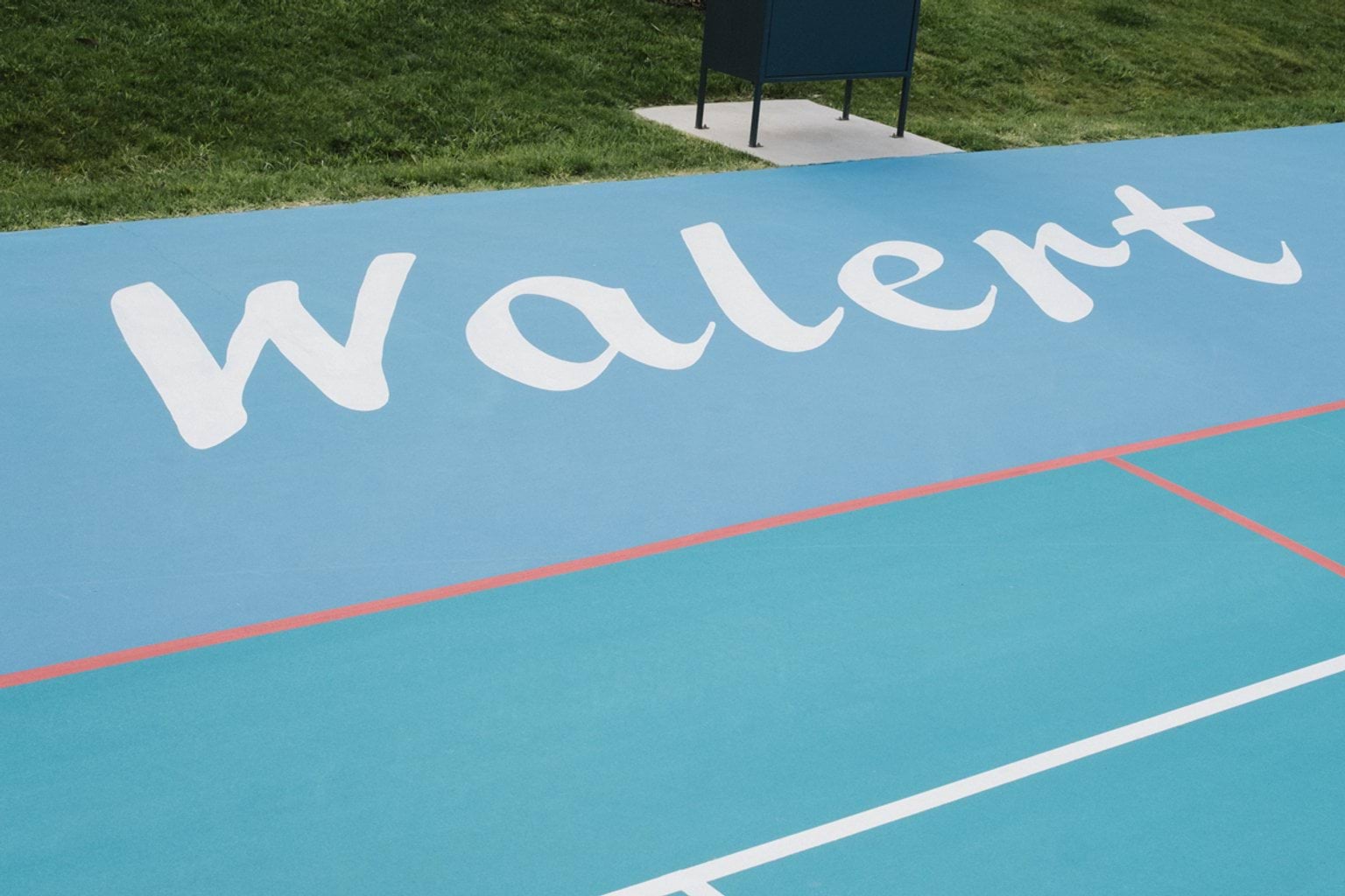 Blue outdoor court area with court lines and letters spelling 'Walert'