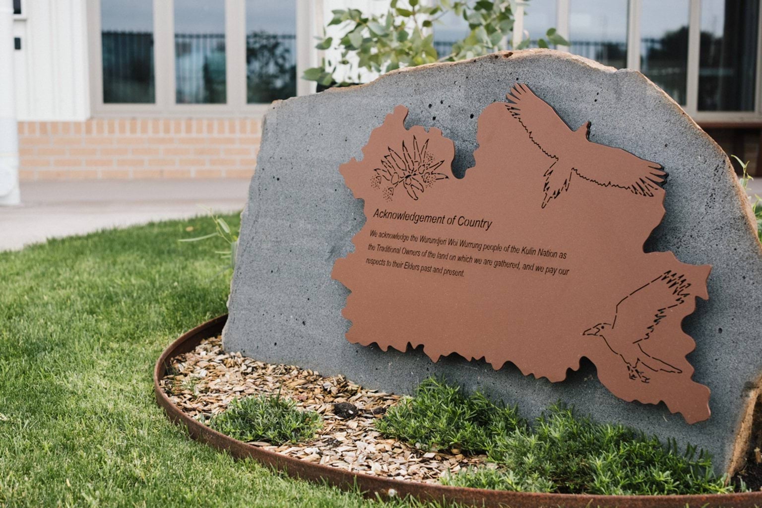 Garden area with garden bed and stone with acknowledgement of country engraved