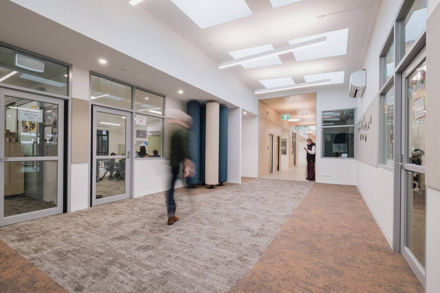 Breakout area with soft poles, felt pin board along the walls and grey and brown carpet
