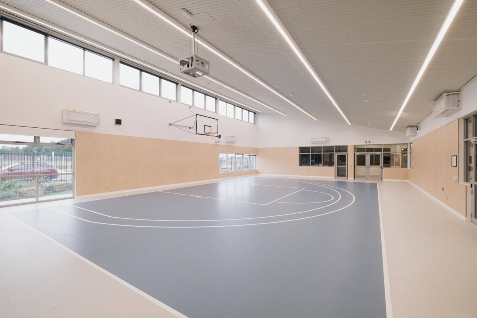 Indoor basketball half-court with a blue surface