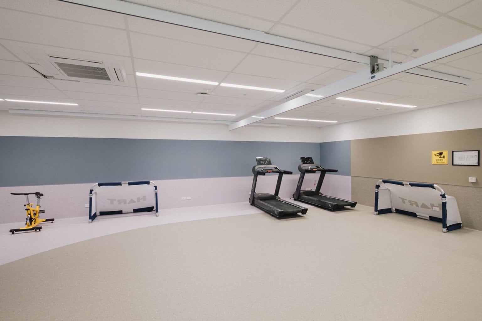 Indoor gym space with soccer nets, an exercise bike and two treadmills