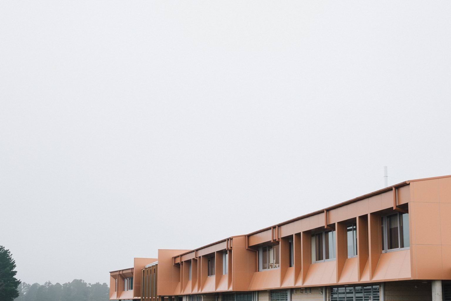 Orange building with grey fog and trees