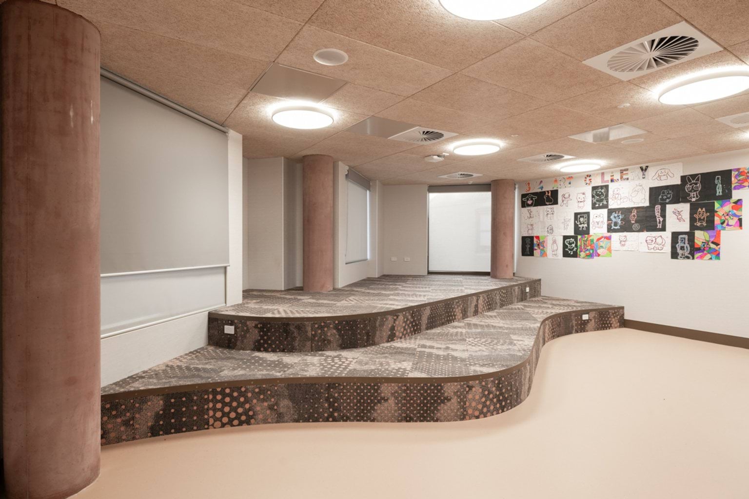 Indoor area with curved carpeted platforms and cement pillars