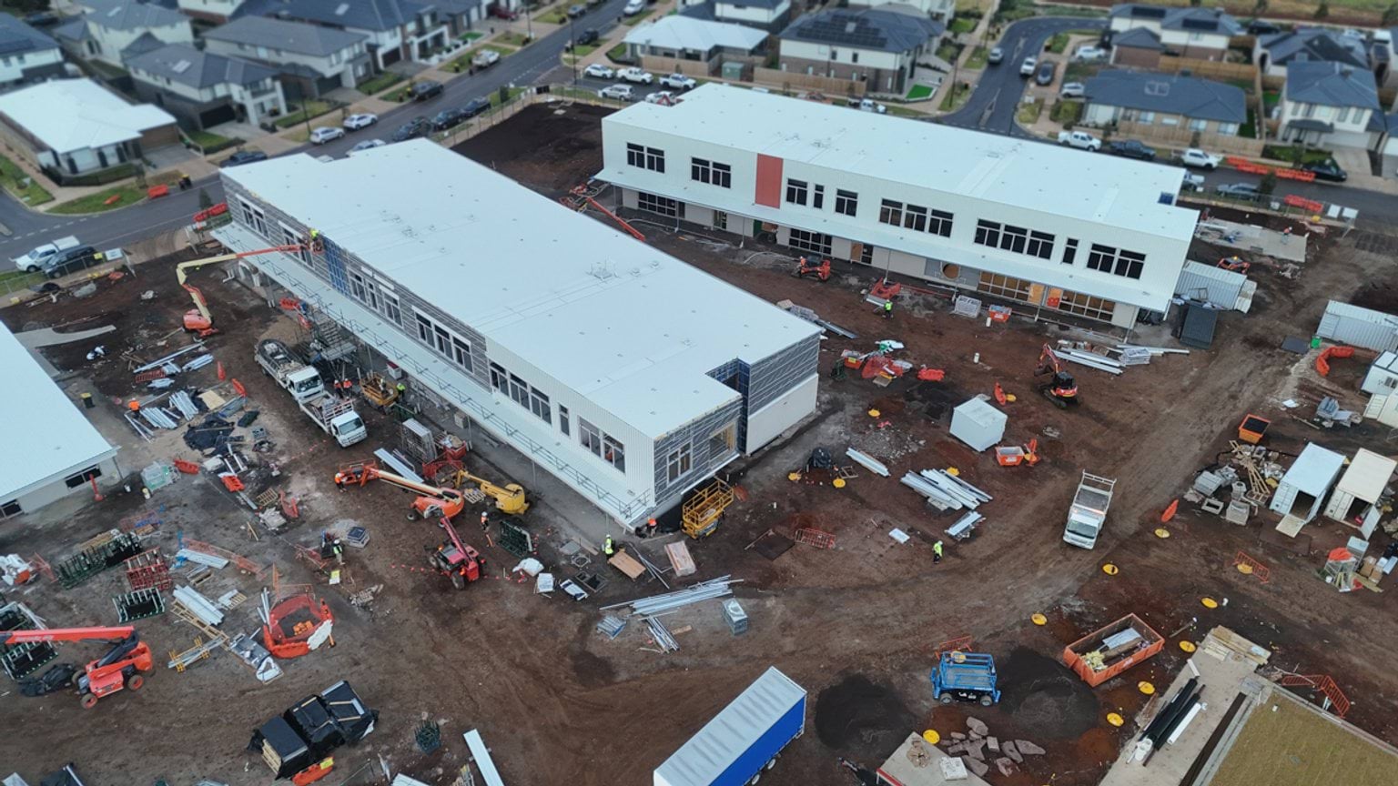 View from above of construction site with two large, multi-storey buildings