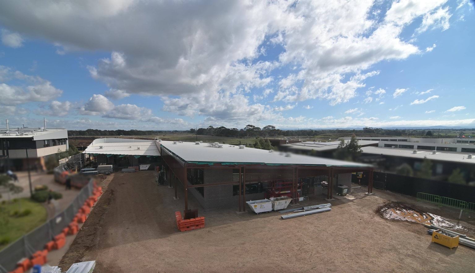 An aerial image of a school building surrounded by construction fencing