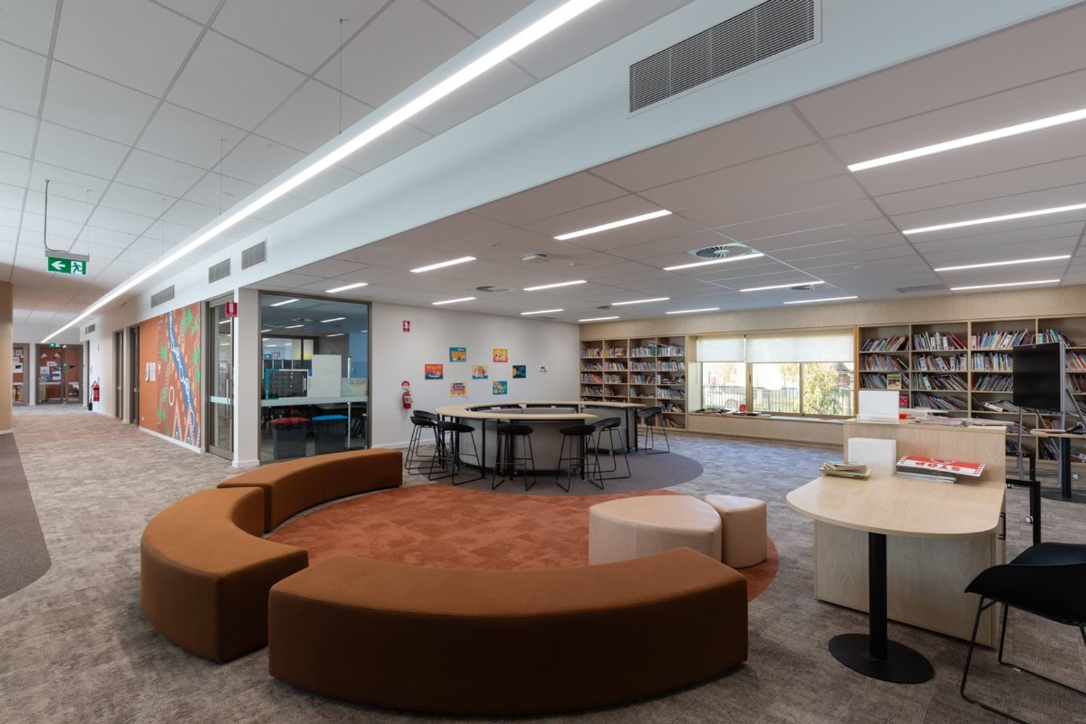 Open library and breakout space with curved seating, tables and chairs